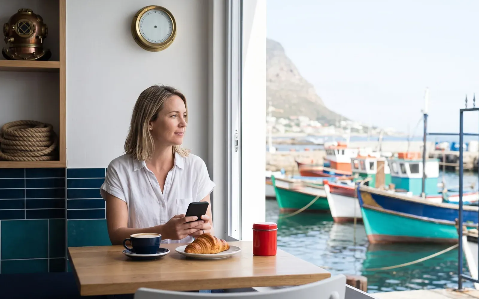 A nautical harbour-side coffee shop in Kalk Bay, with fishing boats in the harbour through the window